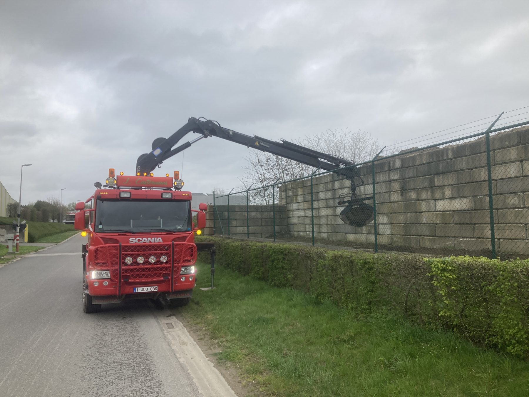 Kraanwagen met betonblokken langs de weg