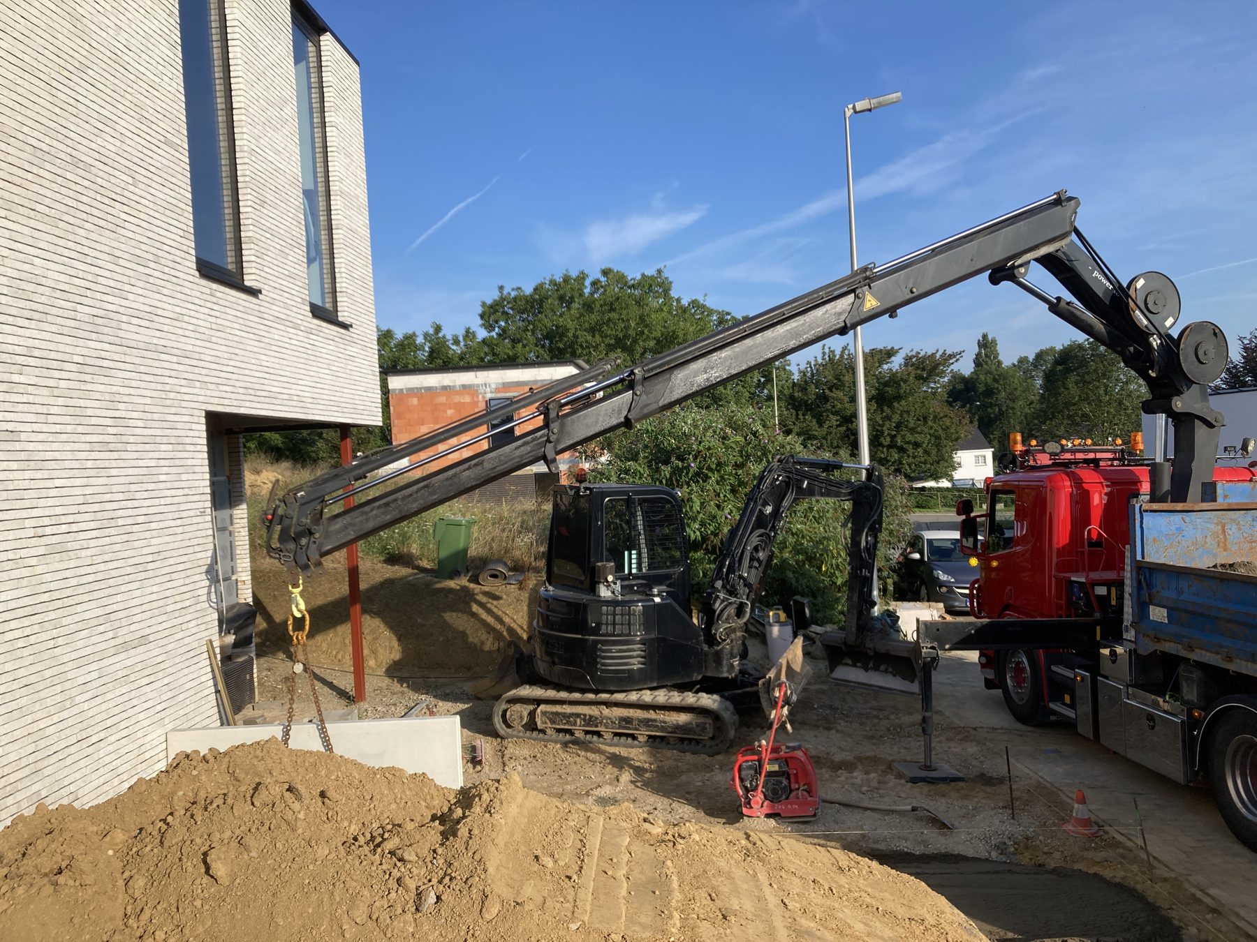 Graafmachine en kraanwagen aan het werk op een bouwterrein