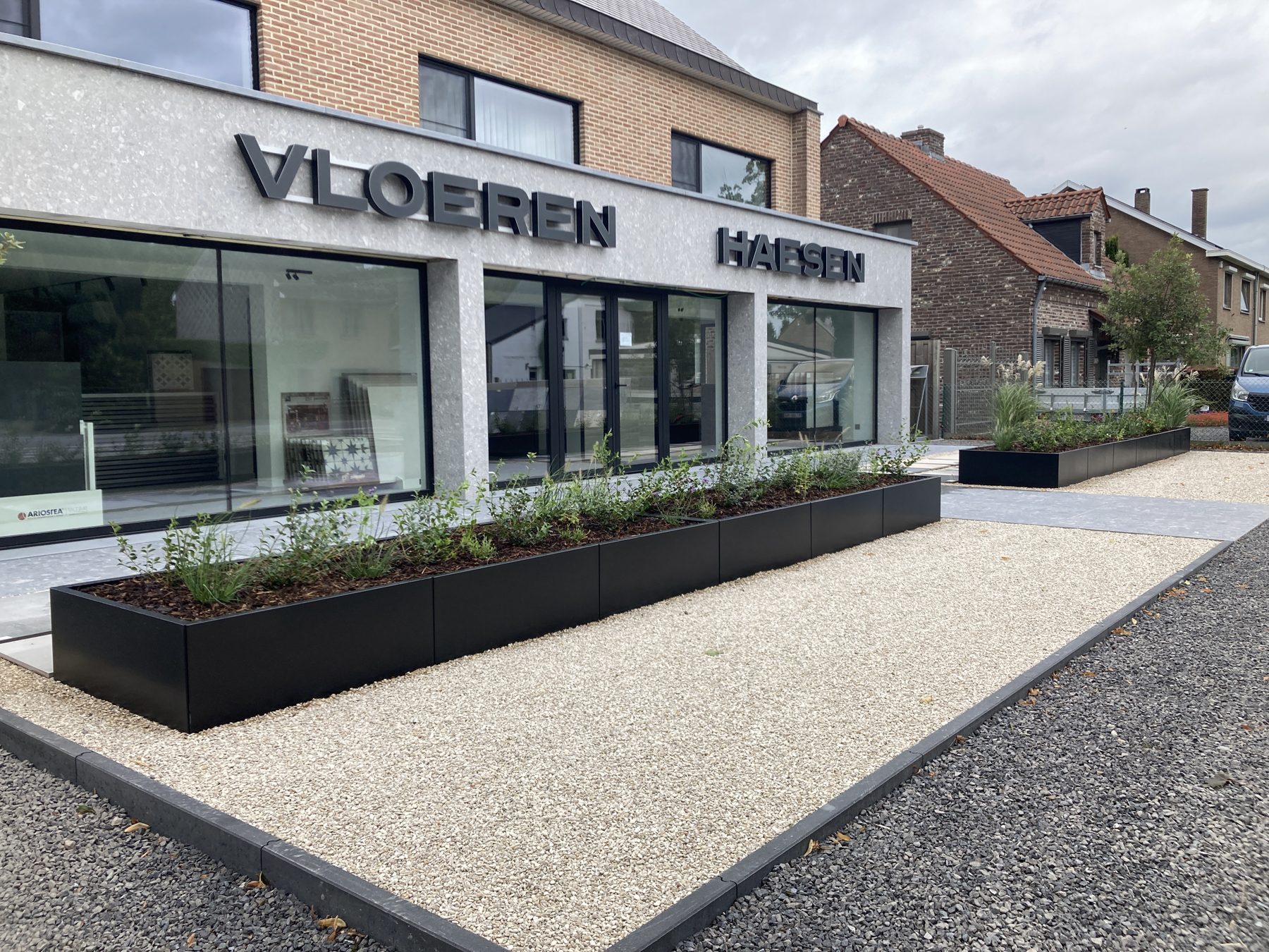 Bedrijfspand met plantbakken en dolomietverharding