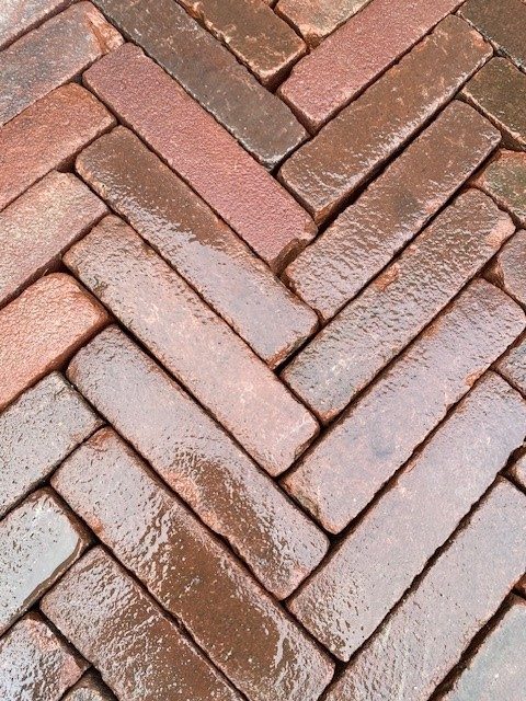 Detail van een klinkerverharding in visgraatverband