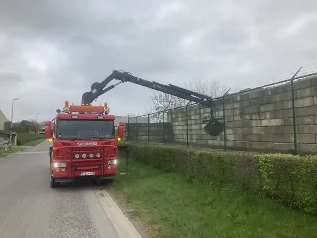Kraanwagen met betonblokken langs de weg